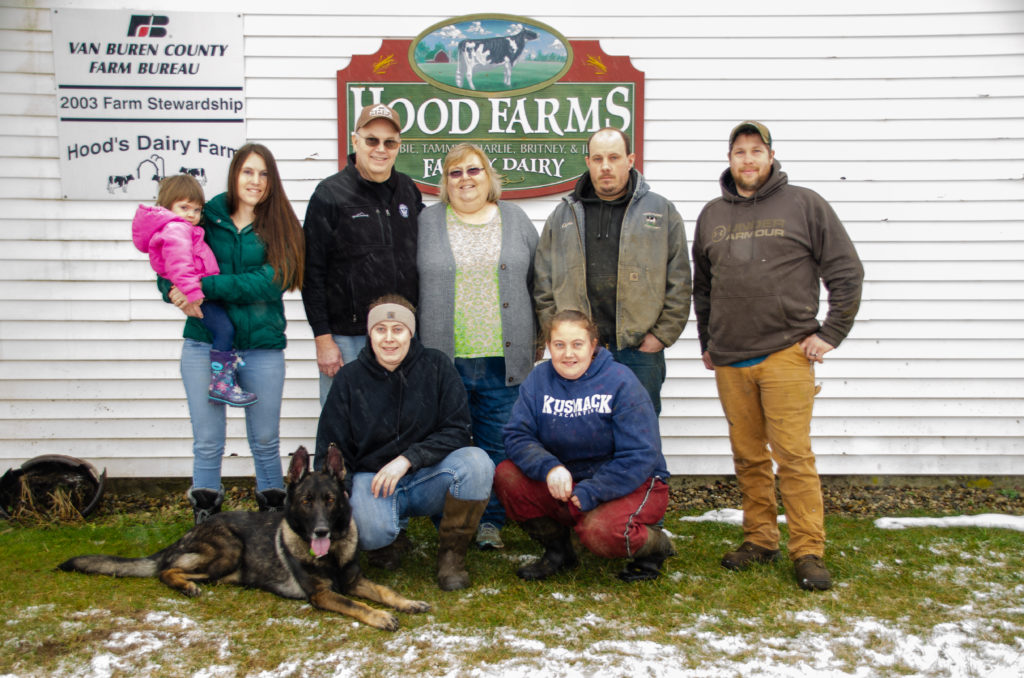 Tim Hood and his family in front of their Hood Farms sign. A part of a farming commitment.